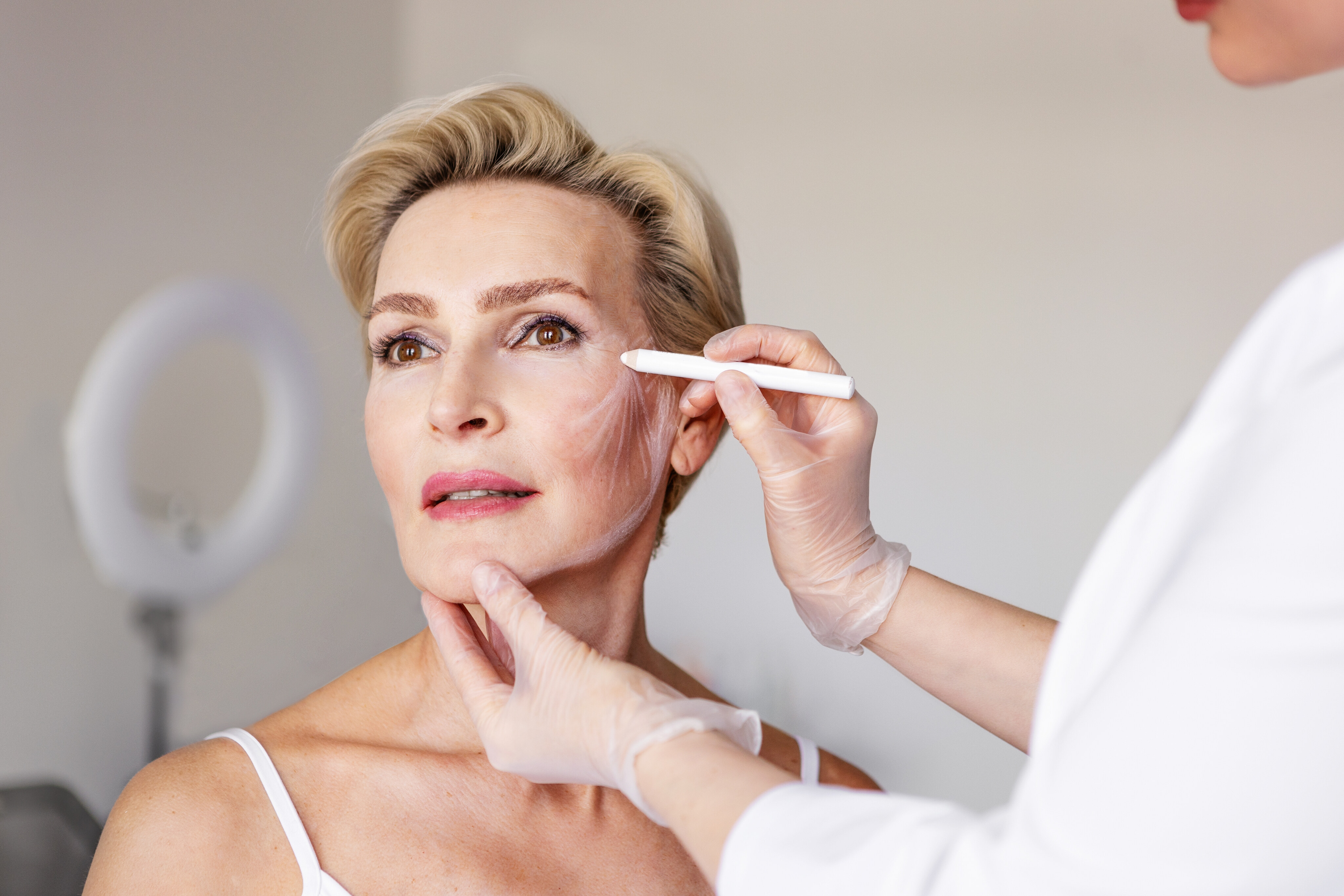 Woman with smooth, lifted facial contours resting against a neutral backdrop