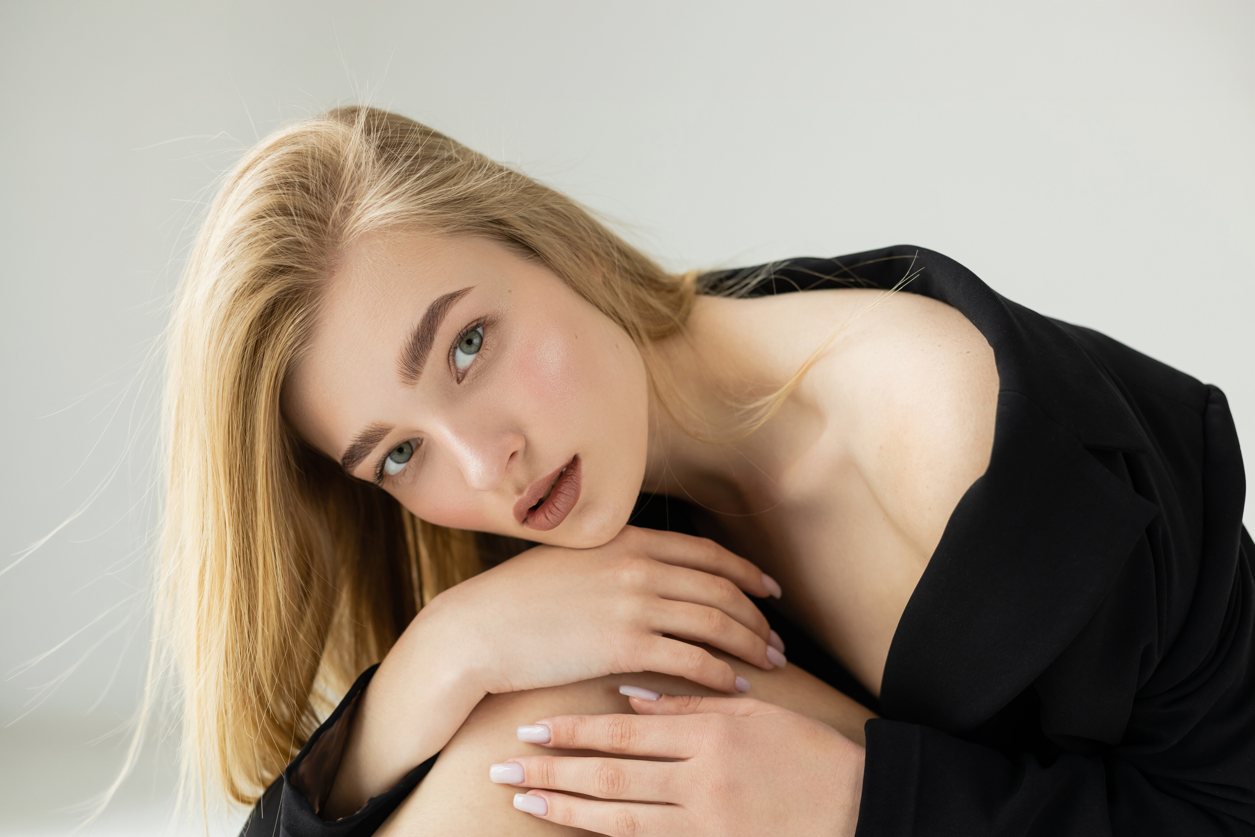 Woman in profile against a soft neutral backdrop, showing a refined nasal line